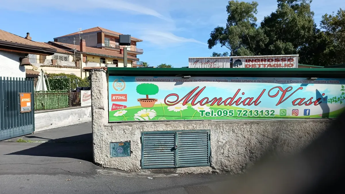 Il cancello con il cartello STIHL Service e l'insegna Mondial Vasi sul muro