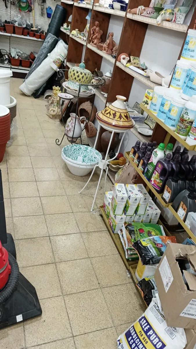 L'interno del negozio, con vasi, ceramiche e concimi sugli scaffali
