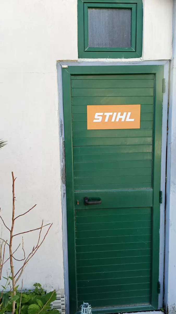 La porta verde dell'officina, con l'adesivo STIHL