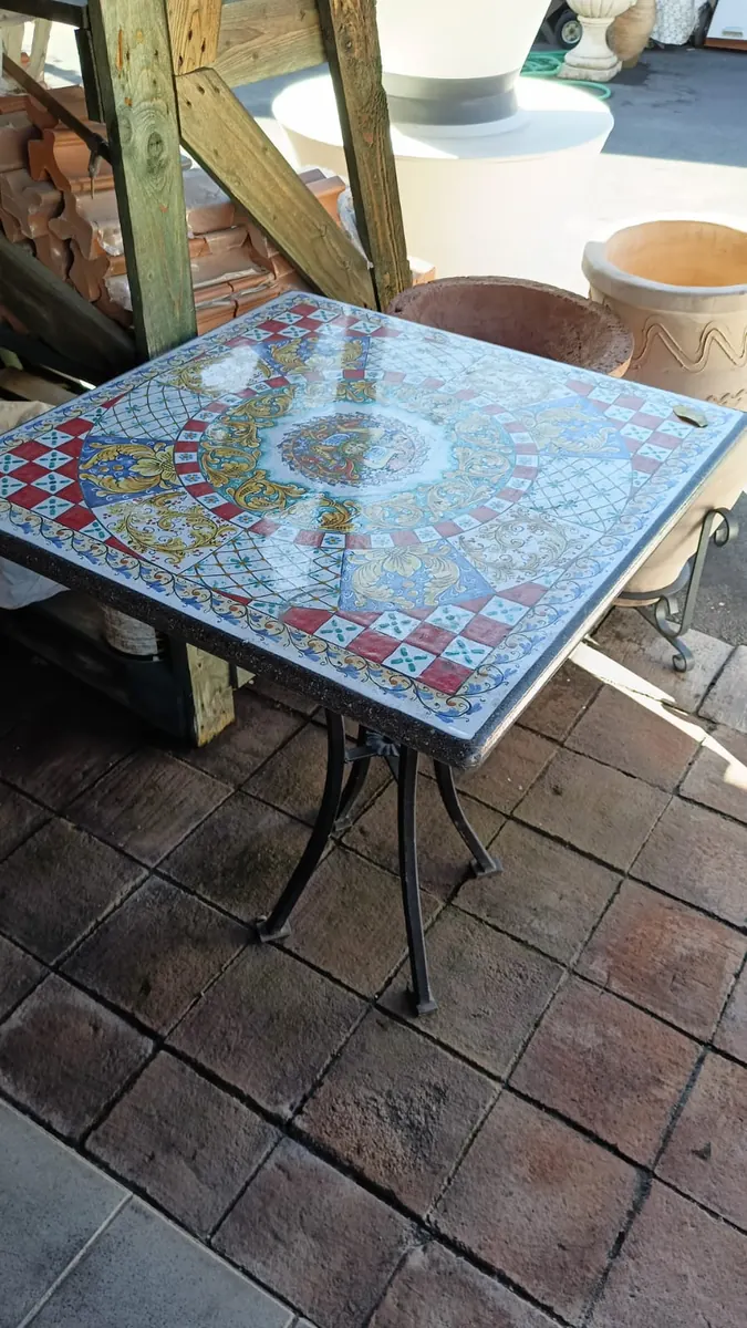 Tavolo in ceramica decorata con le gambe in ferro